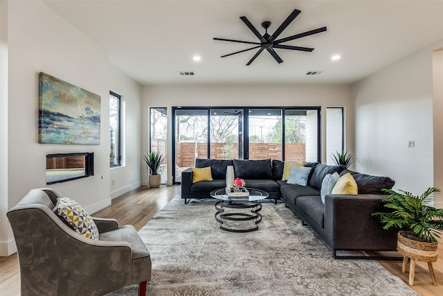 living room with ceiling fan and light wood-type flooring