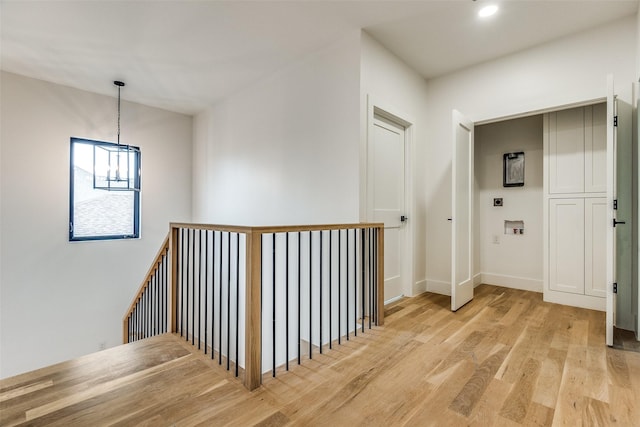 corridor featuring a chandelier and light hardwood / wood-style floors