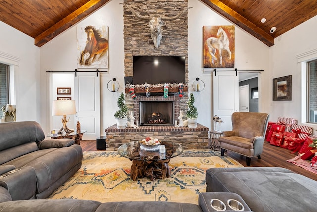 living room with hardwood / wood-style flooring, a barn door, wooden ceiling, and high vaulted ceiling