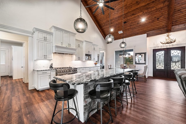 kitchen featuring decorative backsplash, pendant lighting, light stone counters, and wooden ceiling