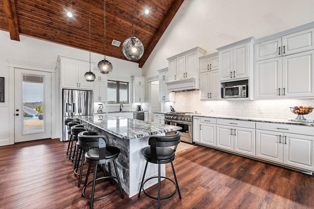 kitchen with light stone countertops, a center island, stainless steel appliances, backsplash, and custom range hood