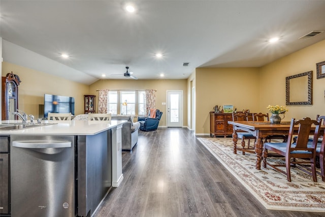 kitchen with a center island with sink, dark hardwood / wood-style flooring, dishwasher, vaulted ceiling, and sink