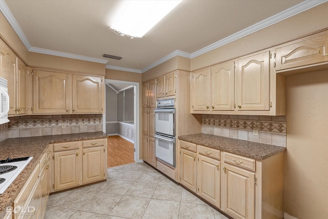 kitchen featuring light tile patterned floors, white appliances, tasteful backsplash, and crown molding