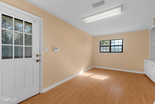 interior space with light hardwood / wood-style flooring and ornamental molding