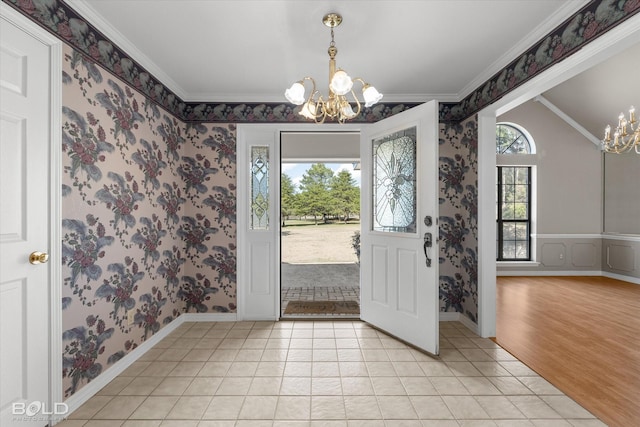 tiled foyer with crown molding and an inviting chandelier