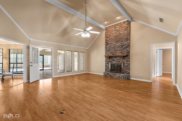 unfurnished living room with a brick fireplace, ceiling fan, crown molding, lofted ceiling with beams, and hardwood / wood-style flooring