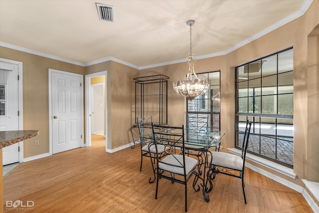 dining area with ornamental molding, a chandelier, and wood-type flooring