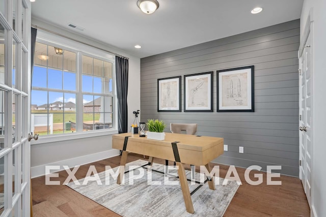 office featuring hardwood / wood-style flooring, wood walls, and french doors