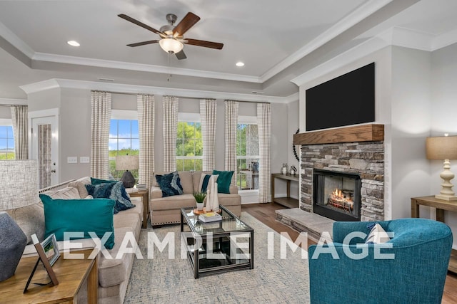 living room with a fireplace, ceiling fan, plenty of natural light, and wood-type flooring