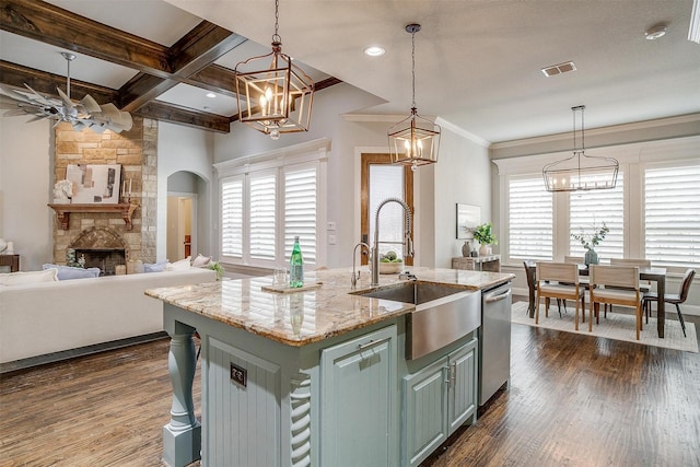 kitchen with coffered ceiling, sink, a center island with sink, beamed ceiling, and a fireplace