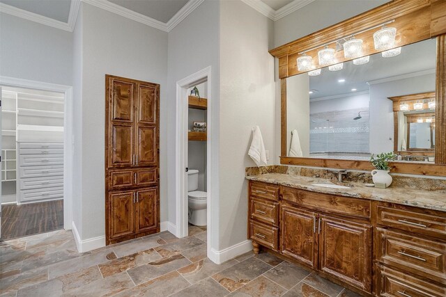 bathroom featuring a shower, crown molding, vanity, and toilet