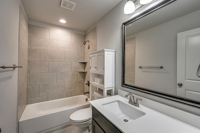 full bathroom with tile patterned floors, vanity, tiled shower / bath, and toilet