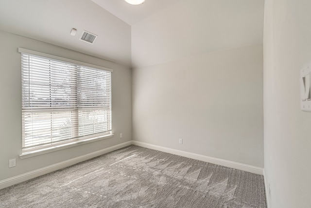 empty room featuring lofted ceiling and carpet flooring