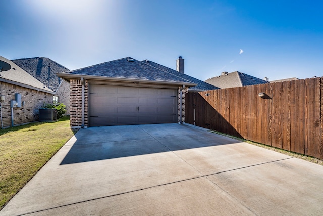 view of front facade with a garage, a front lawn, and central air condition unit