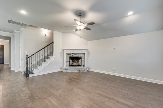 unfurnished living room featuring hardwood / wood-style floors, a stone fireplace, crown molding, vaulted ceiling, and ceiling fan