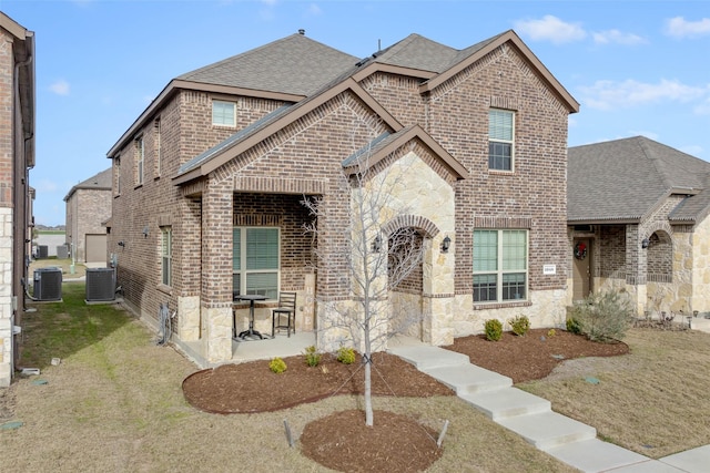 view of front property with a patio, central AC, and a front lawn