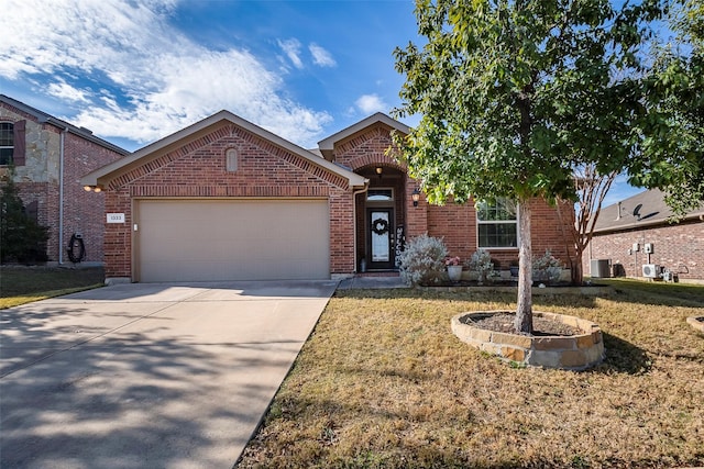 front of property featuring a front yard, central AC unit, and a garage