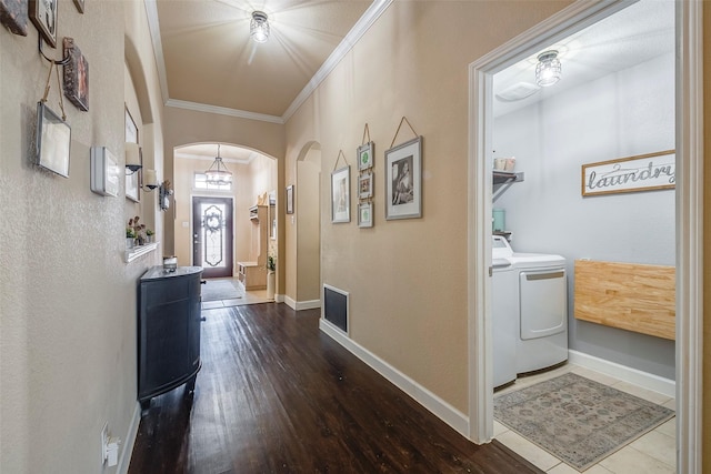 hall with washer and dryer, wood-type flooring, and ornamental molding