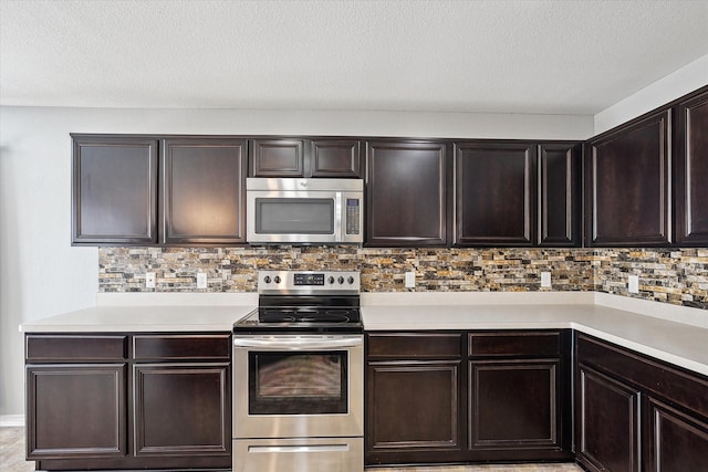 kitchen featuring decorative backsplash, dark brown cabinetry, a textured ceiling, and appliances with stainless steel finishes