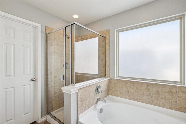 bathroom featuring independent shower and bath