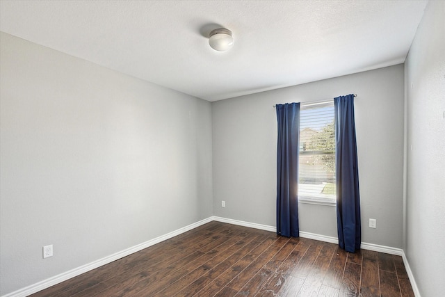 unfurnished room with dark hardwood / wood-style flooring