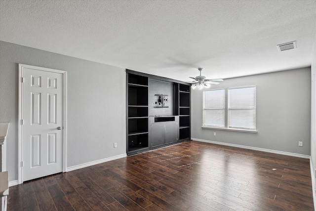 unfurnished living room featuring a textured ceiling, built in features, ceiling fan, and dark wood-type flooring