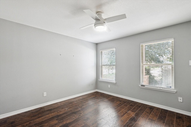 empty room featuring dark hardwood / wood-style flooring, a wealth of natural light, and ceiling fan