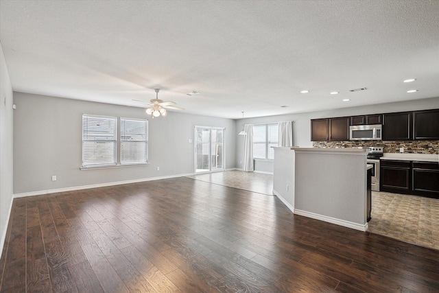 kitchen featuring decorative backsplash, ceiling fan, dark hardwood / wood-style floors, dark brown cabinetry, and stainless steel appliances