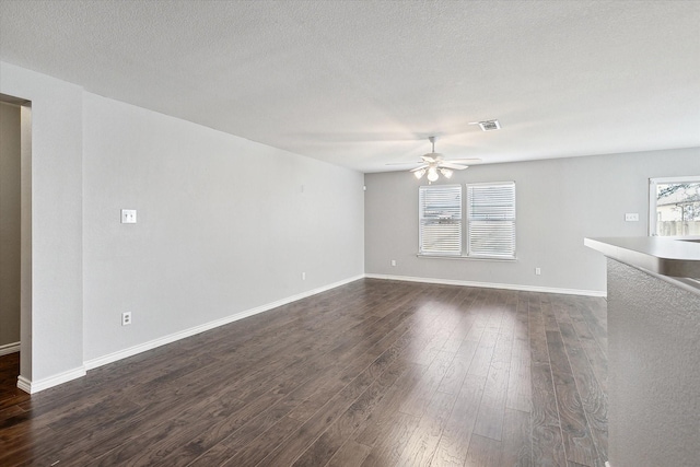 interior space with a textured ceiling, dark hardwood / wood-style flooring, ceiling fan, and a healthy amount of sunlight