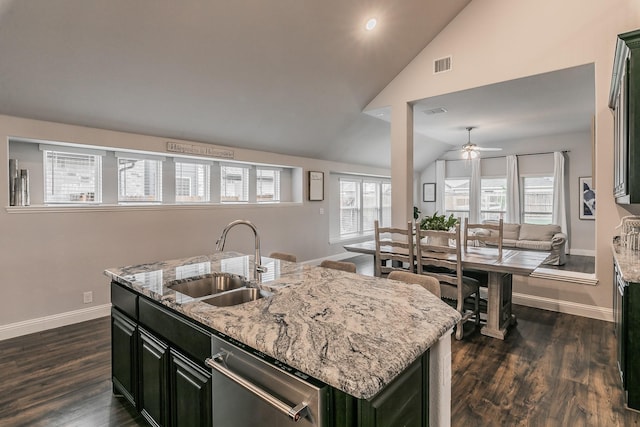 kitchen with a kitchen island with sink, sink, dishwasher, and light stone counters