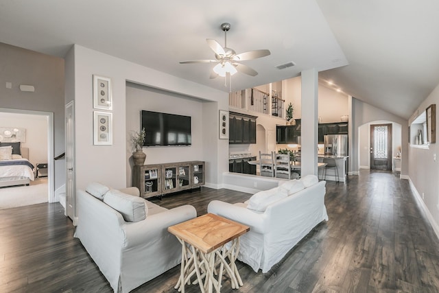 living room featuring vaulted ceiling, ceiling fan, and dark wood-type flooring