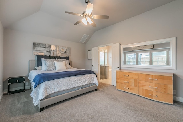 carpeted bedroom with ceiling fan, lofted ceiling, and ensuite bath