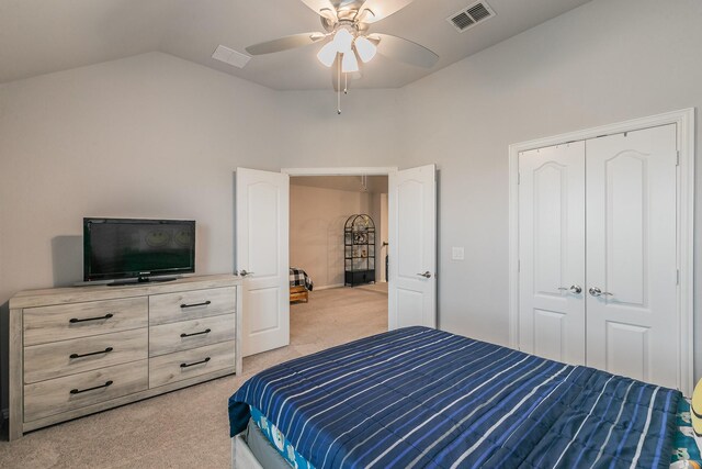 bedroom with ceiling fan, vaulted ceiling, light colored carpet, and a closet