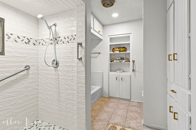 bathroom featuring a textured ceiling, tile patterned floors, and a tile shower