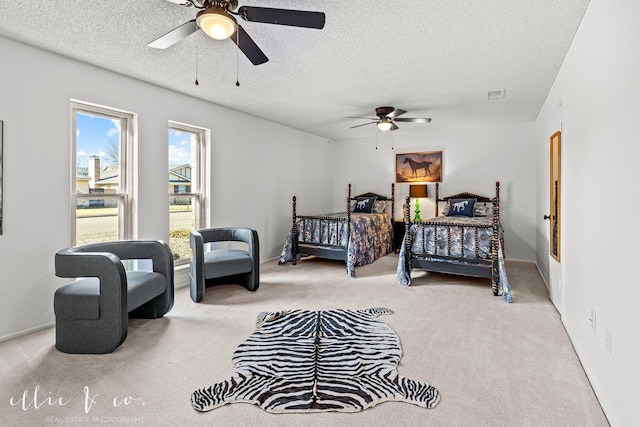 bedroom featuring ceiling fan, light colored carpet, and a textured ceiling