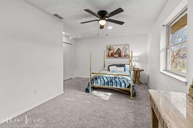 bedroom featuring ceiling fan, a textured ceiling, and carpet floors