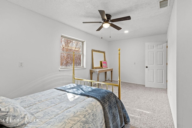 carpeted bedroom featuring ceiling fan and a textured ceiling