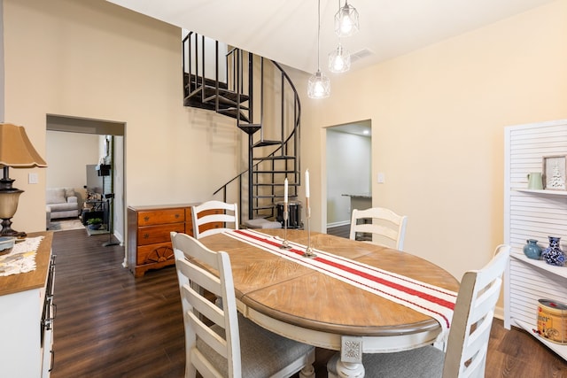 dining area featuring a high ceiling and dark hardwood / wood-style floors