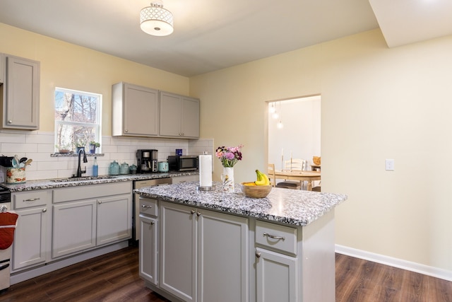 kitchen with sink, gray cabinetry, a center island, stainless steel appliances, and decorative backsplash