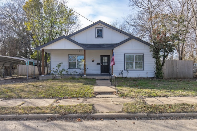 bungalow with covered porch, a front yard, and a carport