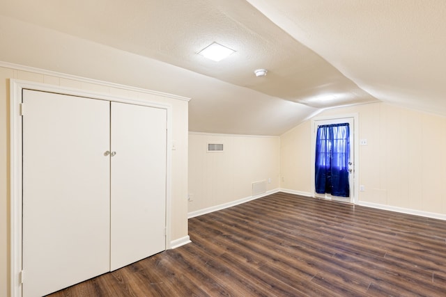 bonus room with dark hardwood / wood-style flooring, lofted ceiling, and a textured ceiling