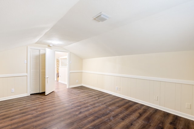 bonus room with vaulted ceiling and dark hardwood / wood-style floors