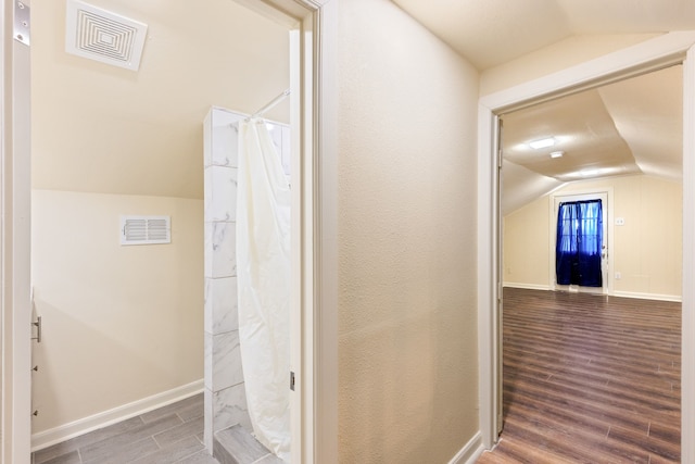 bathroom featuring lofted ceiling