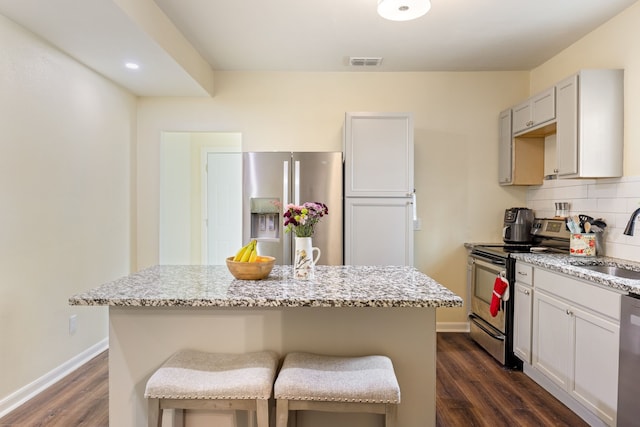 kitchen featuring sink, decorative backsplash, a kitchen island, and appliances with stainless steel finishes