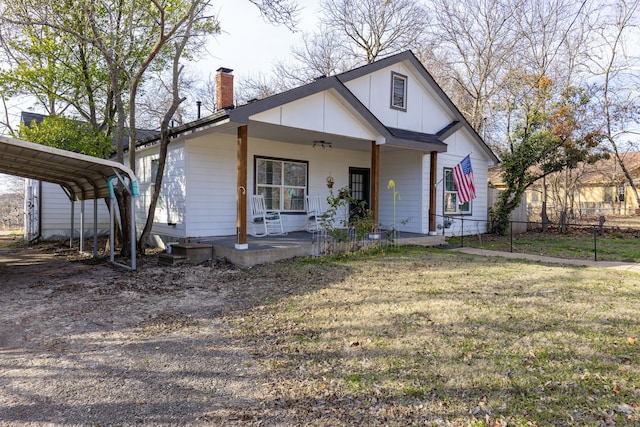 view of front of home with a front yard, a carport, and a porch