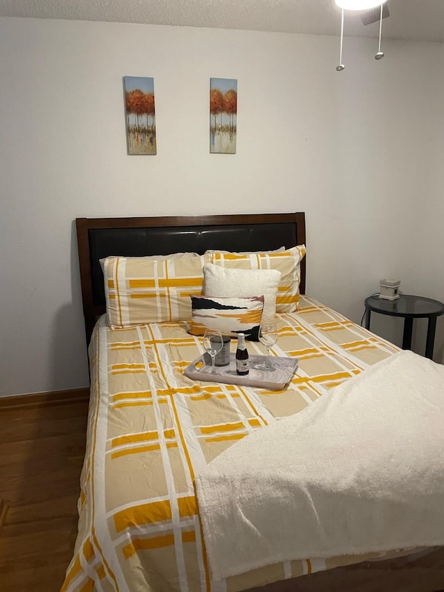 bedroom featuring hardwood / wood-style floors and a textured ceiling