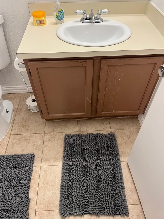 bathroom featuring tile patterned floors, vanity, and toilet