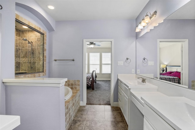 bathroom with ceiling fan, tile patterned flooring, vanity, and tiled tub