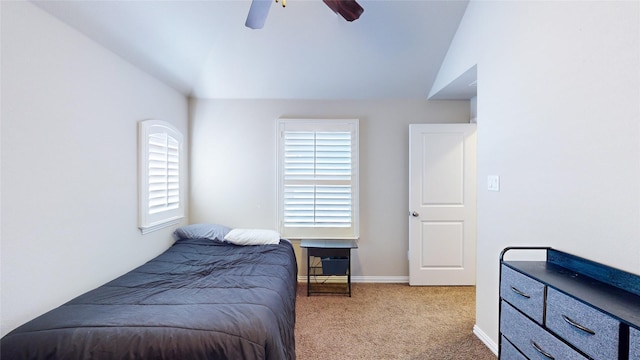 bedroom featuring ceiling fan, vaulted ceiling, and light carpet