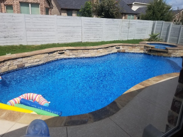 view of pool with an in ground hot tub